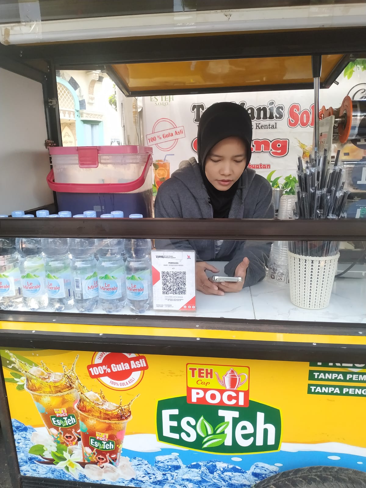 Della pedagang Es Teh Poci tersenyum di gerobak kuning Taman Elektrik Masjid Raya Al-Azhom Tangerang
