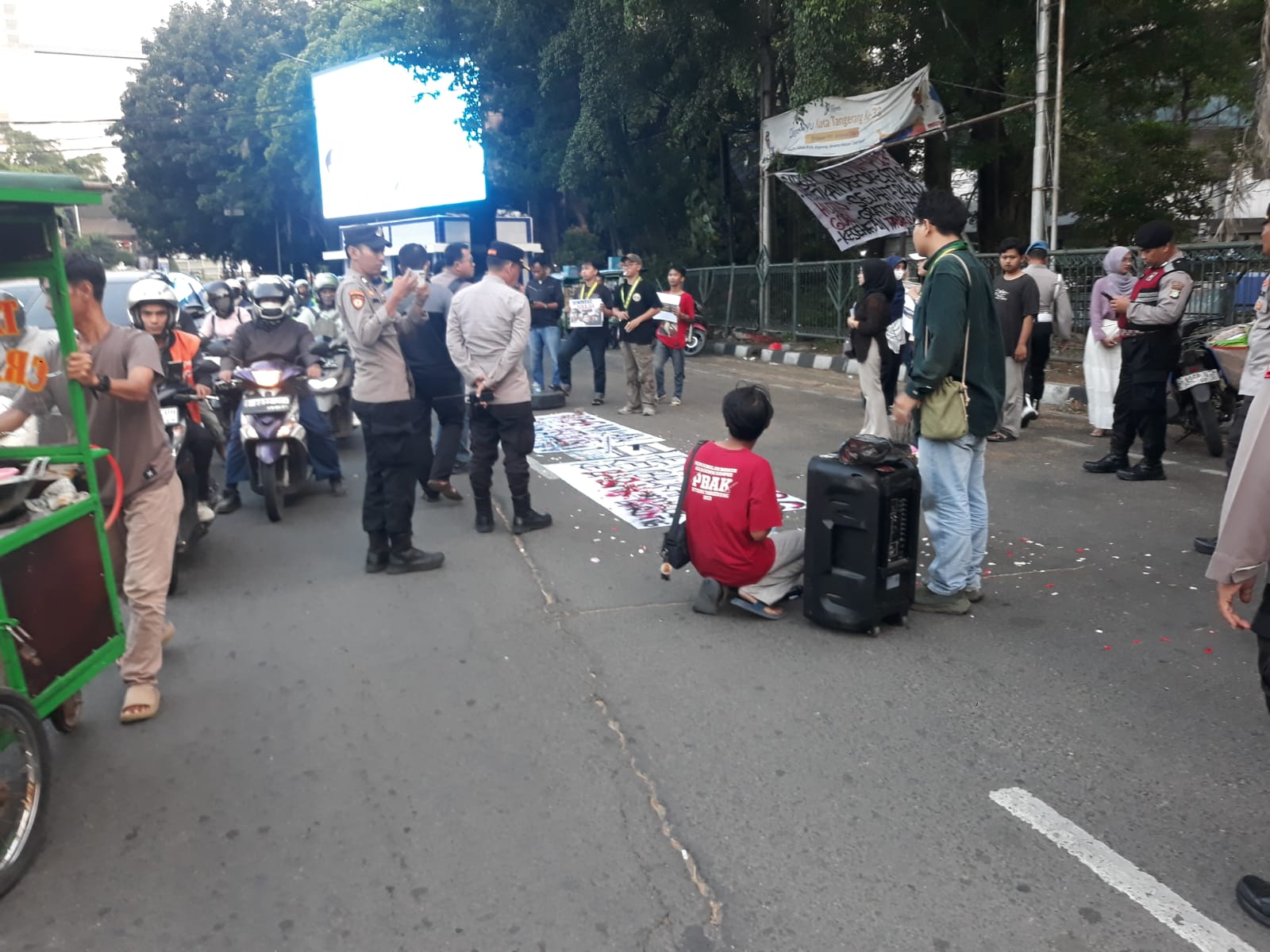 Aparat kepolisian Polsek Tangerang berjaga dan memantau jalannya aksi demo mahasiswa tolak MBG di Taman Gajah, Kota Tangerang, Kamis sore