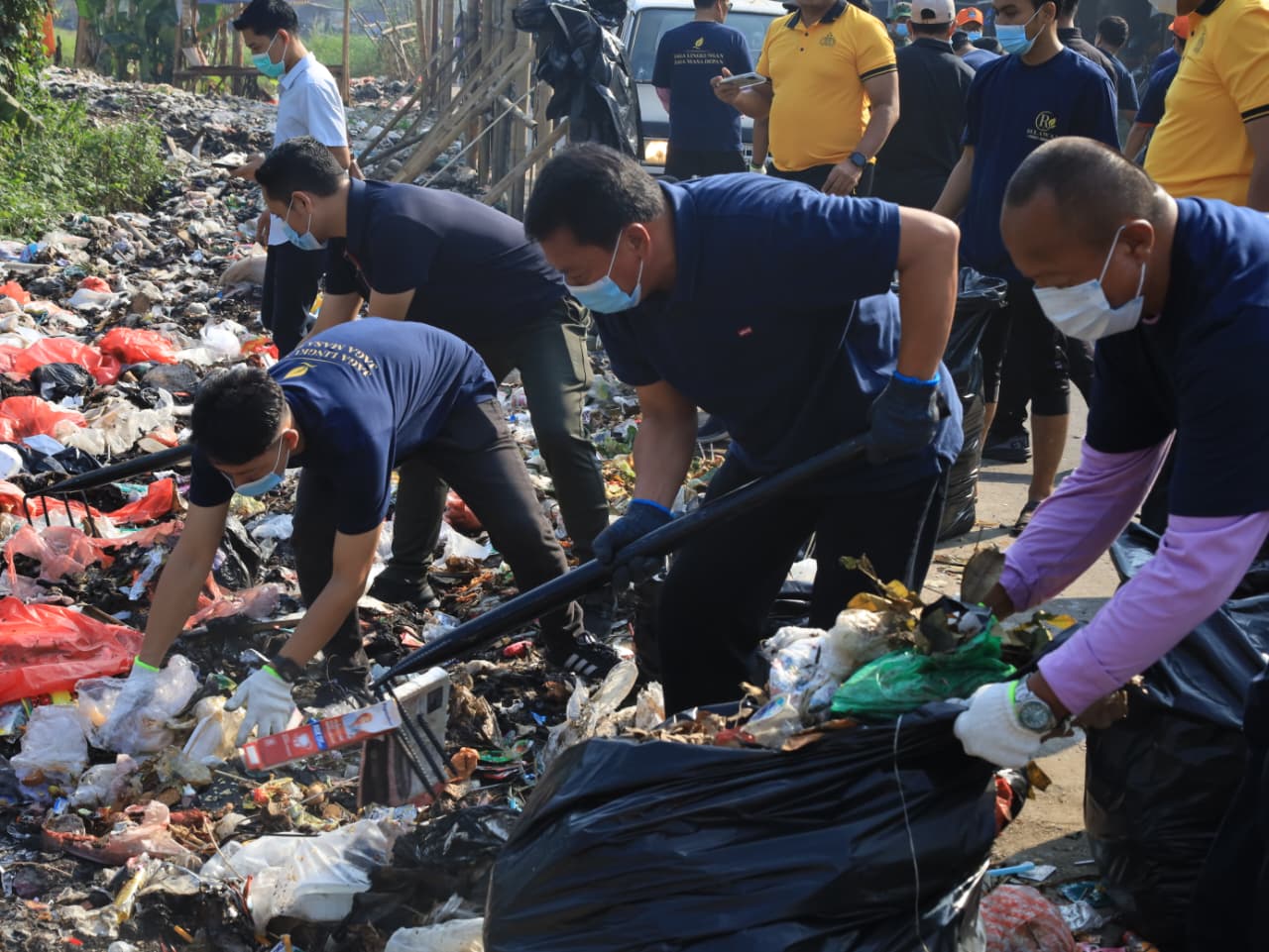 Bupati Tangerang Moch Maesyal Rasyid mengenakan kaos biru dan topi memegang garpu sampah bersama puluhan petugas TNI berseragam loreng, Polri, petugas kebersihan dan mahasiswa bergotong royong membersihkan tumpukan sampah di Desa Tobat Balaraja pada kegiatan Jumat Bersih 19 Juni 2026