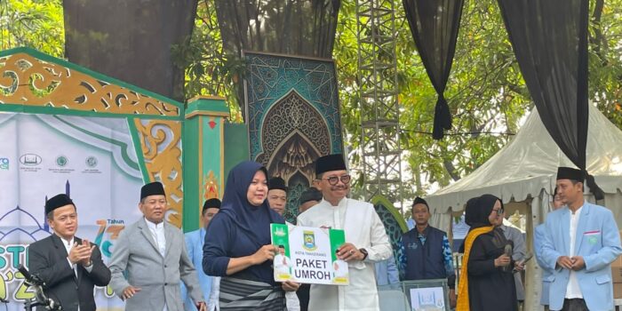 Wali Kota Tangerang Sachrudin menyerahkan plakat paket umroh kepada warga pemenang doorprize Jalan Sehat Sarungan Festival Al Azhom 2026