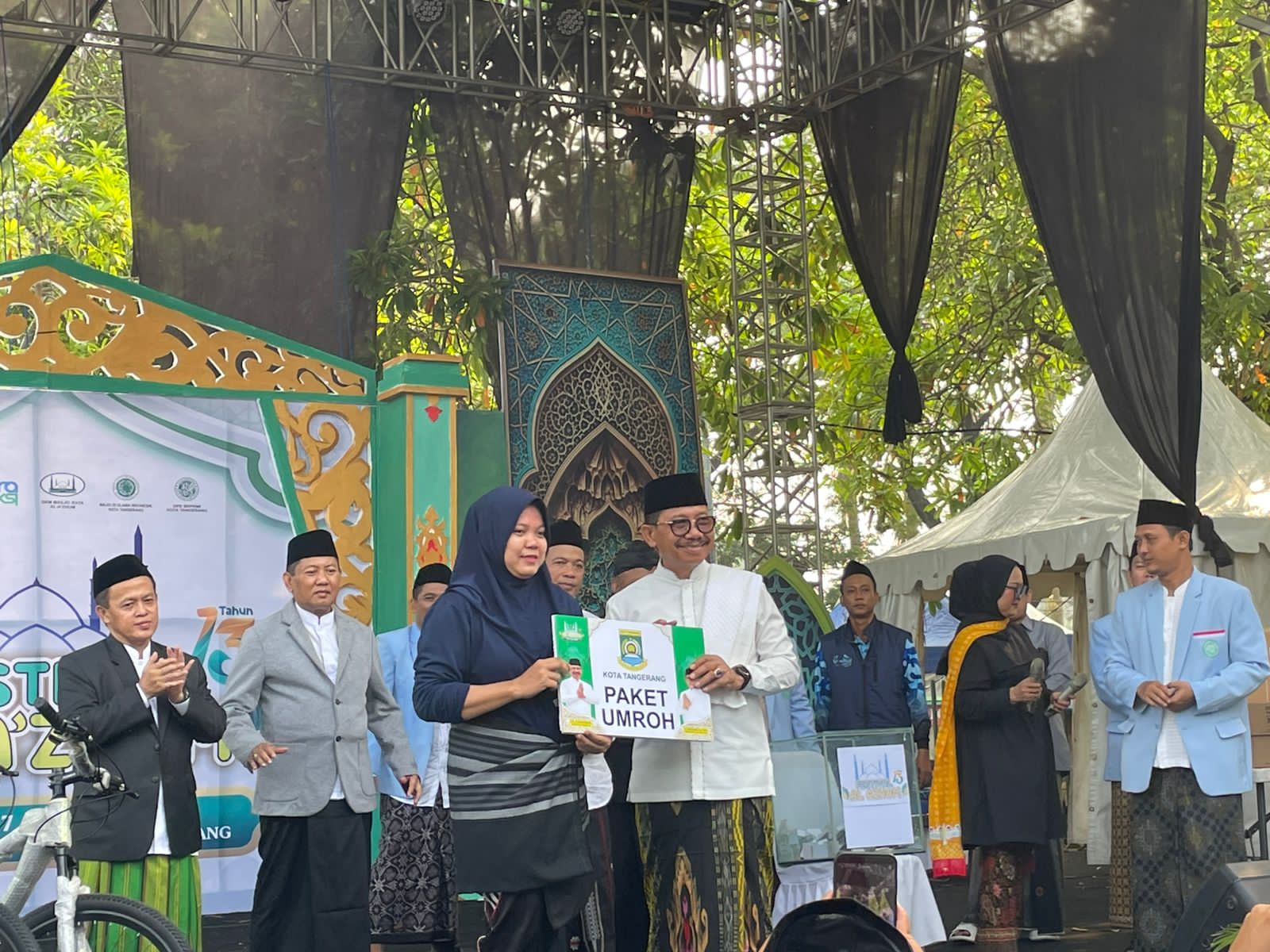 Wali Kota Tangerang Sachrudin menyerahkan plakat paket umroh kepada warga pemenang doorprize Jalan Sehat Sarungan Festival Al Azhom 2026
