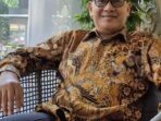 ekonom konstitusi defiyan cori pakai kemeja batik kacamata wawancara