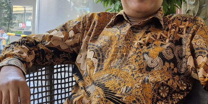 ekonom konstitusi defiyan cori pakai kemeja batik kacamata wawancara