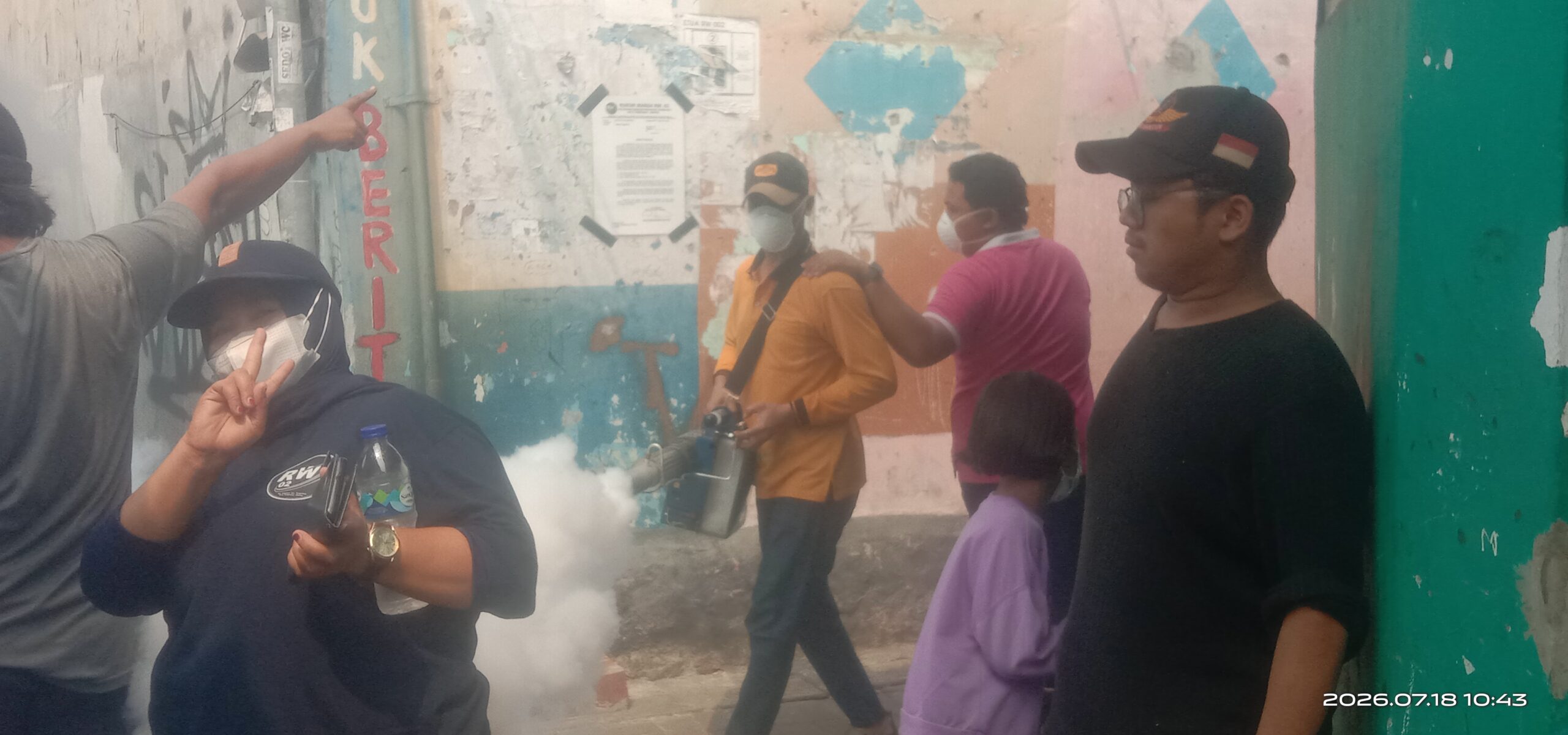 Warga mendampingi petugas saat proses pengasapan untuk memberantas sarang nyamuk DBD.