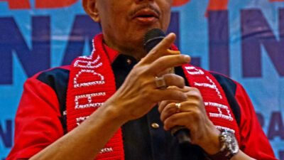 Ketum Madas Nusantara KRH HM Jusuf Rizal berpidato memakai peci hitam dan syal merah