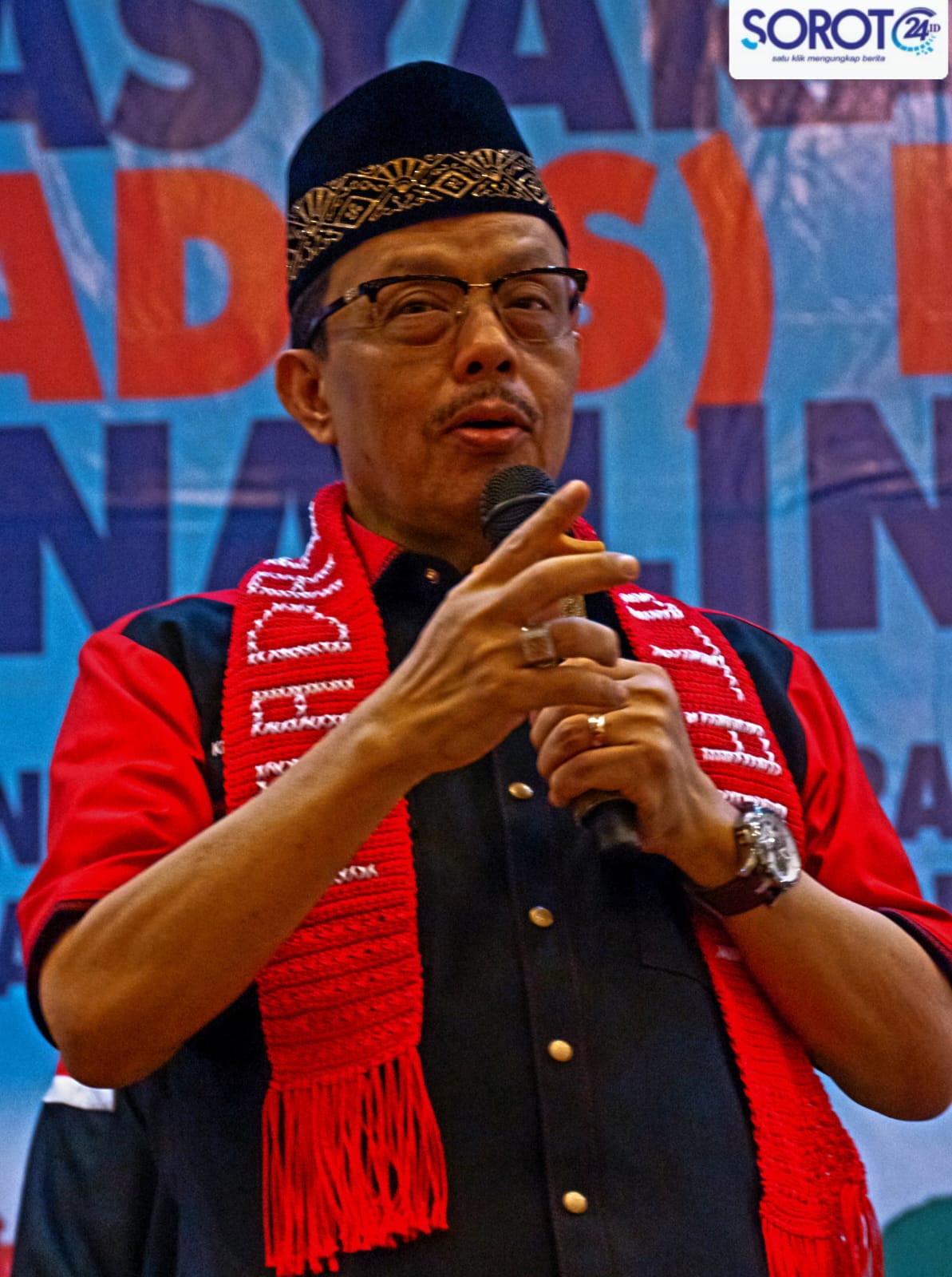 Ketum Madas Nusantara KRH HM Jusuf Rizal berpidato memakai peci hitam dan syal merah