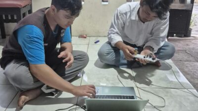 Alat pendeteksi kebocoran gas dengan lampu LED biru dan merah terhubung ke laptop