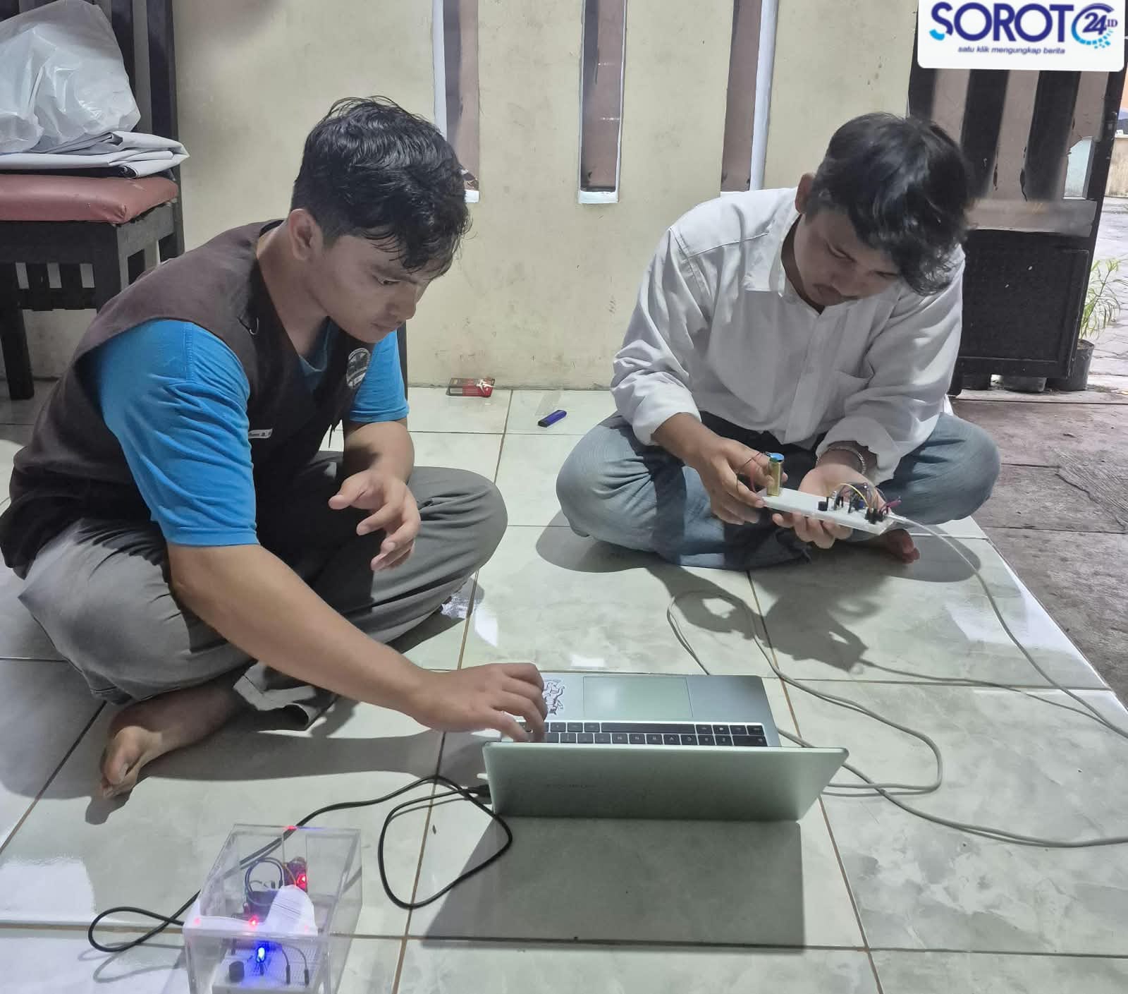 Alat pendeteksi kebocoran gas dengan lampu LED biru dan merah terhubung ke laptop