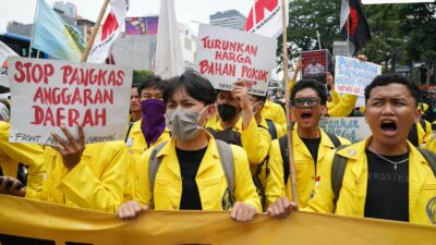 Mahasiswa UI jaket kuning membawa spanduk Stop Pangkas Anggaran Daerah dan Turunkan Harga Bahan Pokok