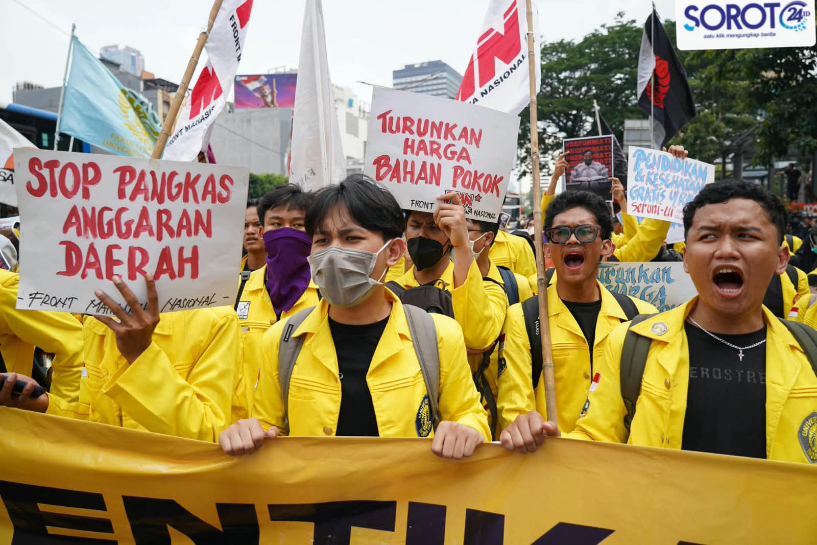 Mahasiswa UI jaket kuning membawa spanduk Stop Pangkas Anggaran Daerah dan Turunkan Harga Bahan Pokok