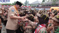 Bupati Tangerang bersalaman dengan anggota Pramuka perempuan di lapangan