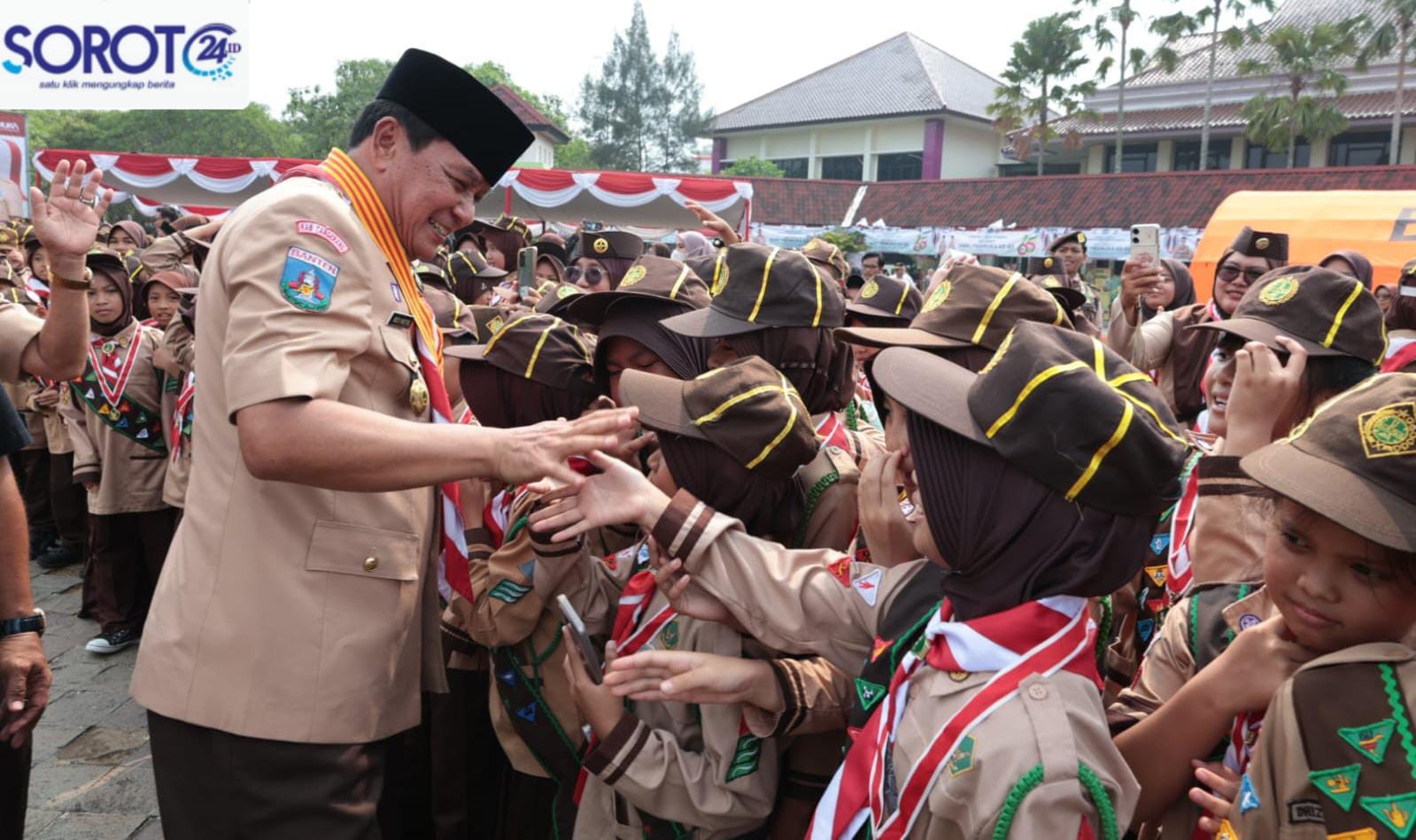 Bupati Tangerang bersalaman dengan anggota Pramuka perempuan di lapangan