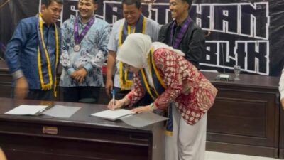 Sri Panggung Lestari menandatangani dokumen pelantikan DPP IMKT di hadapan pengurus