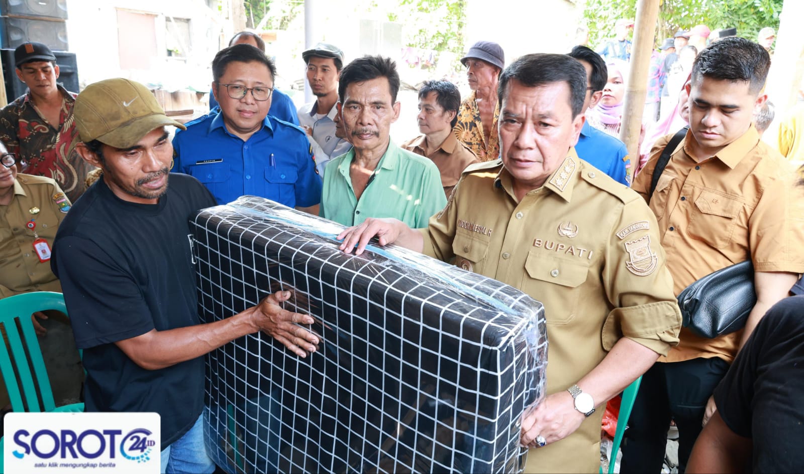 Bupati Maesyal menyerahkan bantuan kepada warga terdampak.